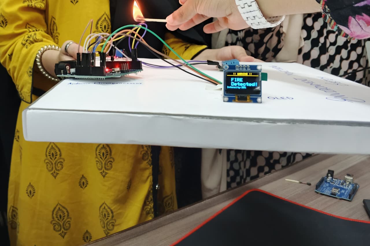 Student demonstrating a fire-detection sensor project